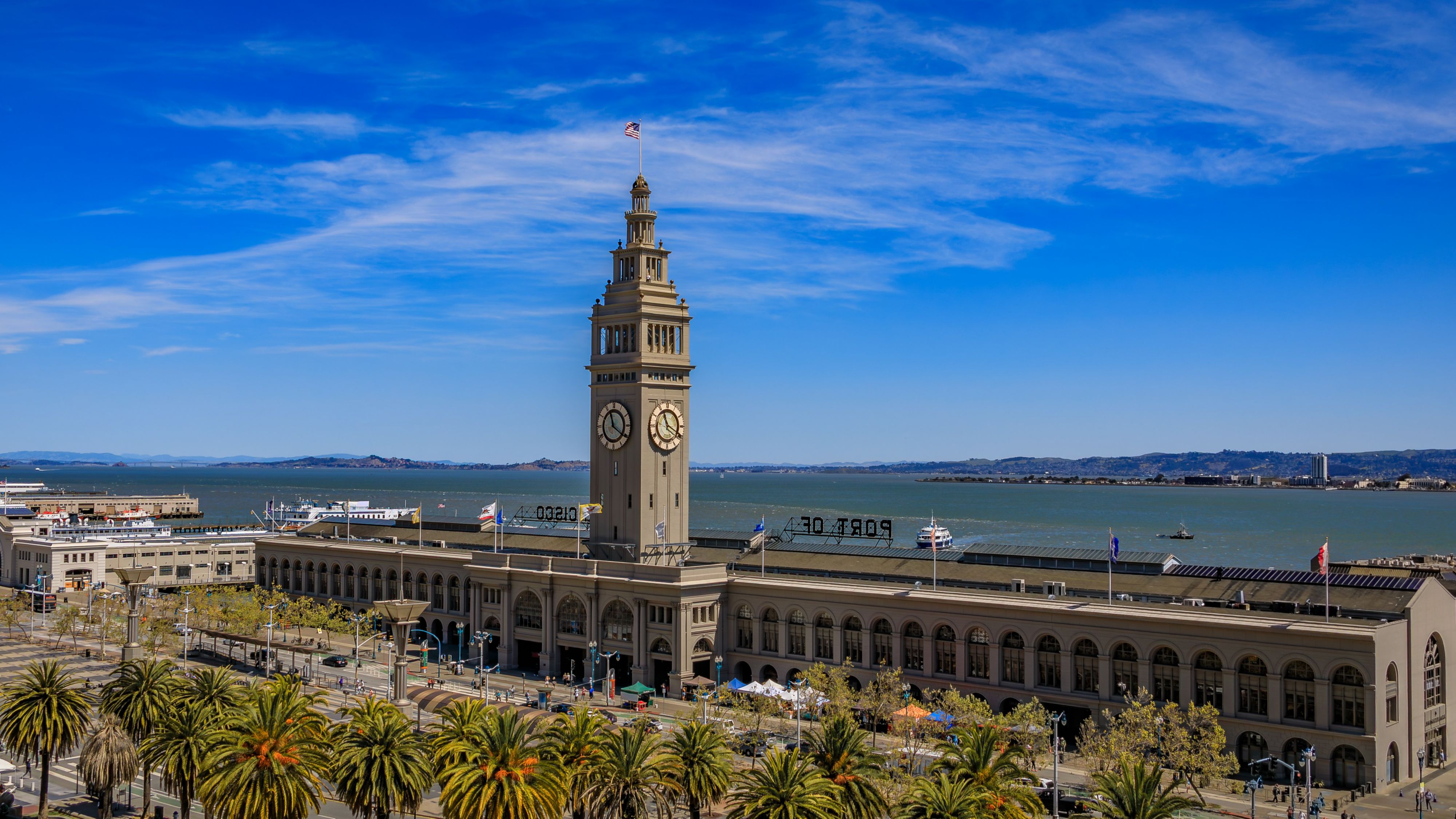Aerial view of the historic Ferry Building with the iconic clock tower and palm trees on the San Francisco waterfront in San Francisco, United States